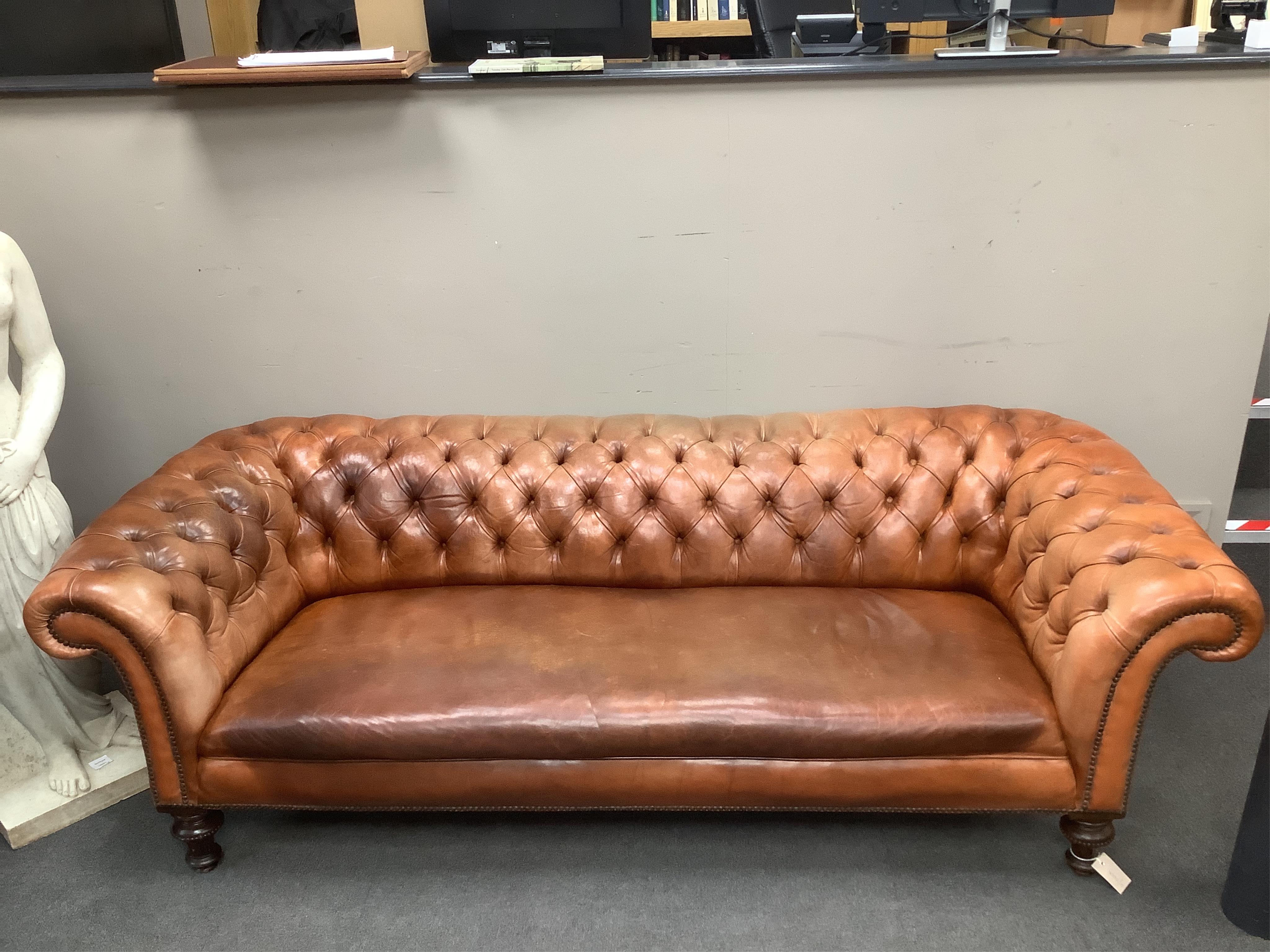 A Victorian chesterfield settee upholstered in hand dyed deep buttoned tan leather, on turned fluted feet, width 210cm, depth 92cm, height 65cm. Condition - good